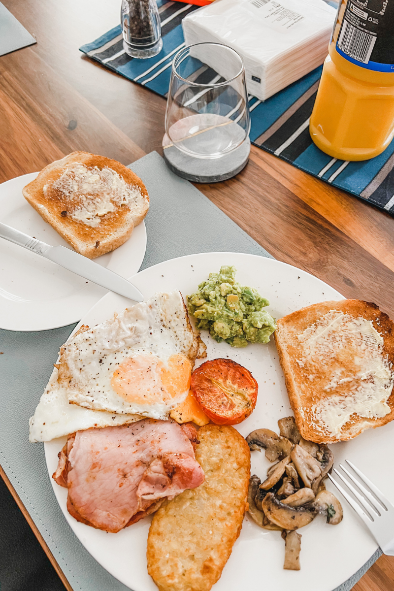 Image of a big breakfast - toast, hashbrown, bacon, avocado, mushrooms and orange juice